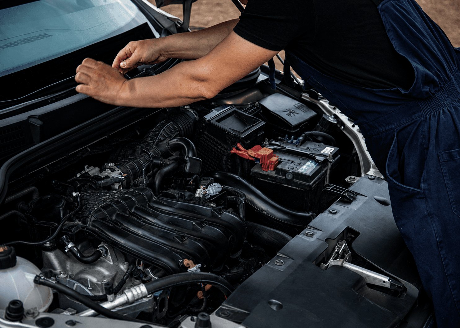 Profissional realizando manutenção no compartimento do motor